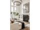 Elegant living room features statement chandelier, fireplace, and scenic views through expansive windows at 11573 Bent Tree Ct, Zionsville, IN 46077