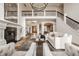 Open concept living room with grand staircase, fireplace, and view to the entry foyer at 11573 Bent Tree Ct, Zionsville, IN 46077