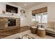 Bright living room with stone fireplace, wood floors, and large window with woven shade at 11573 Bent Tree Ct, Zionsville, IN 46077
