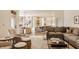 Spacious living room with a large gray sofa, hardwood floors, and open view into the kitchen at 11573 Bent Tree Ct, Zionsville, IN 46077