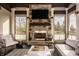 Bright sunroom featuring a stone fireplace, comfortable seating, and views of the landscape at 11573 Bent Tree Ct, Zionsville, IN 46077