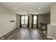 A sunlit living room with wood-look floors, modern lighting, and large windows with stylish green curtains at 1208 Chapman Dr, Westfield, IN 46074