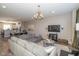 Open-concept living room with plush seating, modern lighting, and views of the dining area and kitchen at 1208 Chapman Dr, Westfield, IN 46074