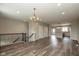 An open-concept living room with hardwood floors, a staircase, a modern light fixture, and white trim at 1208 Chapman Dr, Westfield, IN 46074