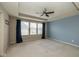 A spacious main bedroom with a tray ceiling, plush carpet, and large windows covered with dark drapes at 1208 Chapman Dr, Westfield, IN 46074