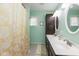 Bathroom with double sink vanity, dark cabinets, and a shower with decorative yellow curtain at 12107 Castle Row Overlook, Carmel, IN 46033