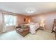 Cozy pink bedroom with natural light, loveseat, carpeting and bedside tables with lamps at 12107 Castle Row Overlook, Carmel, IN 46033