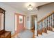 Inviting foyer with a light pink door, staircase with wrought iron spindles, and hardwood flooring at 12107 Castle Row Overlook, Carmel, IN 46033