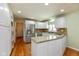 Modern kitchen features white cabinets, granite countertops, stainless steel appliances and hardwood flooring at 12107 Castle Row Overlook, Carmel, IN 46033