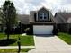 Charming home featuring a two-car garage, manicured lawn, and traditional architectural details at 1223 Blackthorne S Trl, Plainfield, IN 46168