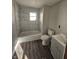 Newly renovated bathroom featuring a shower-tub combo, stylish tile, and modern vanity at 123 S Butler Ave, Indianapolis, IN 46219