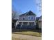 Two-story home with covered porch and classic architectural details under a clear, blue sky at 123 S Butler Ave, Indianapolis, IN 46219