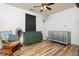 Bedroom with wood-look floors, rocking chair, dresser, and gray crib at 12329 Wolf Run Rd, Noblesville, IN 46060