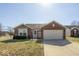 Charming brick home featuring an attached two-car garage and manicured front lawn at 12329 Wolf Run Rd, Noblesville, IN 46060