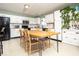 Spacious kitchen with white cabinets, black appliances, and a dining table in the center at 12329 Wolf Run Rd, Noblesville, IN 46060