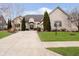 Stately cream brick home featuring manicured landscaping and a long driveway at 14020 Quarter Horse Ct, Carmel, IN 46032