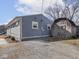 Backyard with a gray house, gravel area, storage shed and blue sky backdrop at 1420 E Market St, Indianapolis, IN 46201