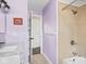 Detailed view of a purple bathroom with tiled shower, marble counter, and unique decor at 1420 E Market St, Indianapolis, IN 46201