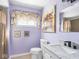 Stylish purple bathroom with marble vanity, floral art, and modern fixtures at 1420 E Market St, Indianapolis, IN 46201