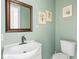 Charming bathroom featuring sage green walls, floral decor, and a modern sink at 1420 E Market St, Indianapolis, IN 46201