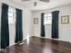 Bright bedroom with natural light, dark curtains, hardwood floors, and simple decor at 1420 E Market St, Indianapolis, IN 46201