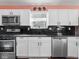 Sleek kitchen featuring white cabinetry, stainless steel appliances, and dark granite countertops at 1420 E Market St, Indianapolis, IN 46201