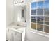 Bright bathroom features a modern vanity with sink, large mirror and natural light from a window at 1535 Arbor Springs Dr, Brownsburg, IN 46112
