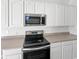 Bright kitchen featuring stainless steel appliances, neutral counters and white cabinetry at 1535 Arbor Springs Dr, Brownsburg, IN 46112