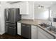 Stainless steel appliances complement the white cabinets and neutral counters of this bright, open kitchen at 1535 Arbor Springs Dr, Brownsburg, IN 46112