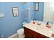 Stylish powder room with blue walls, dark wood vanity, white marble countertop, and artistic accents at 1905 Windsor Ln, Danville, IN 46122