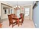Spacious dining room features wooden table and chairs, elegant chandelier and view to living room at 1905 Windsor Ln, Danville, IN 46122