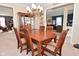 Inviting dining area featuring wooden table, chairs, chandelier, and view to living room at 1905 Windsor Ln, Danville, IN 46122