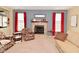 Comfortable living room with brick fireplace, floral armchairs, and large windows with red curtains at 1905 Windsor Ln, Danville, IN 46122