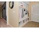 Hallway with custom built-in mudroom shelving and bench with hooks for coats and jackets and a wall clock at 1905 Windsor Ln, Danville, IN 46122