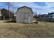 Close-up of the backyard storage shed with double doors, surrounded by a grass lawn and fence at 1905 Windsor Ln, Danville, IN 46122