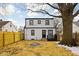 View of the two-story home's backyard, featuring a fire pit, fence, and a mature tree at 1912 Glenridge Dr, Indianapolis, IN 46218