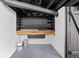 Utility room featuring a workbench, storage shelving, and painted walls at 1912 Glenridge Dr, Indianapolis, IN 46218