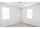 Minimalist bedroom with light wood floors, white walls, and natural light from windows at 1912 Glenridge Dr, Indianapolis, IN 46218