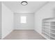 Well-lit room featuring light wood floors, a window, and a built-in storage unit at 1912 Glenridge Dr, Indianapolis, IN 46218
