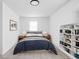 Compact bedroom with built-in shelving, artwork, and warm lighting at 1912 Glenridge Dr, Indianapolis, IN 46218