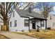 Cozy home with black trim, a dark roof, and a inviting front porch near the drive at 1912 Glenridge Dr, Indianapolis, IN 46218