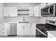 A well-lit kitchen with stainless steel appliances, white cabinets, and an eye-catching backsplash at 1912 Glenridge Dr, Indianapolis, IN 46218