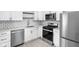 Modern kitchen featuring white cabinets, stainless steel appliances, and subway tile backsplash at 1912 Glenridge Dr, Indianapolis, IN 46218