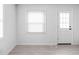 Bright living room with light wood floors, white walls, window, and a door leading to a porch at 1912 Glenridge Dr, Indianapolis, IN 46218