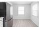 Bright room featuring light wood floors and stainless steel refrigerator with two windows at 1912 Glenridge Dr, Indianapolis, IN 46218