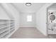A spacious room featuring white walls, light wood floors, and convenient built-in shelving at 1912 Glenridge Dr, Indianapolis, IN 46218