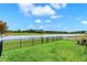 Lush, green backyard features an iron fence, water views, and attractive landscaping at 19795 Chatham Shore Ln, Westfield, IN 46074