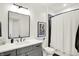 Bright bathroom featuring a gray vanity, framed mirror, and tiled shower with a decorative shower curtain at 19795 Chatham Shore Ln, Westfield, IN 46074