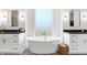 Bright, luxurious bathroom showcasing a freestanding tub with modern fixtures between two vanities at 19795 Chatham Shore Ln, Westfield, IN 46074