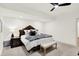 Well-lit bedroom with large bed, ceiling fan, neutral carpet, a sitting bench, and a side table at 19795 Chatham Shore Ln, Westfield, IN 46074